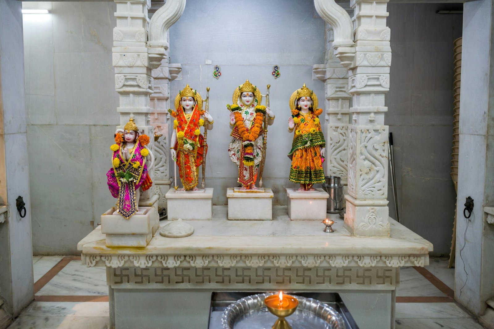 Decorative Hindu deity statues adorned with flowers inside a traditional Mumbai temple.